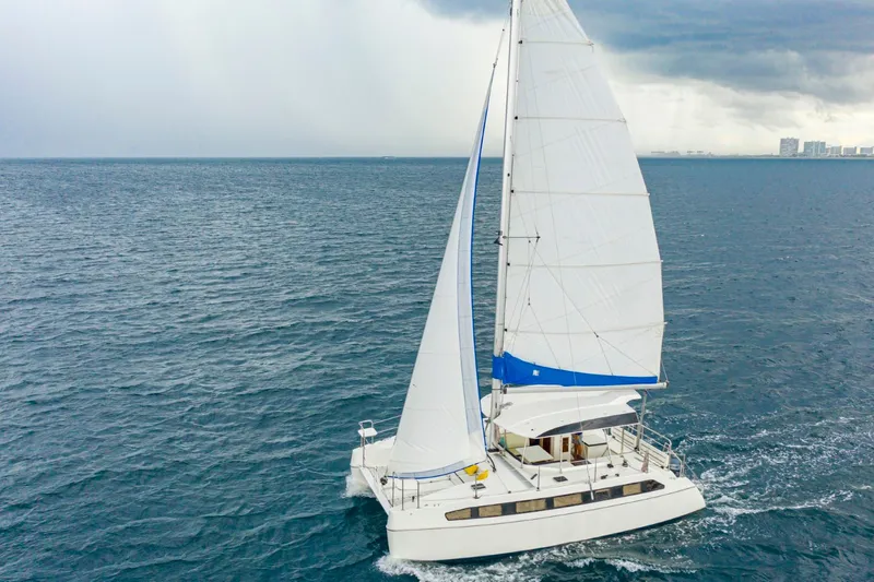  Yacht Photos Pics Sailing catamaran Smart Cat S280, 2025 model, cruising on open sea under cloudy skies.