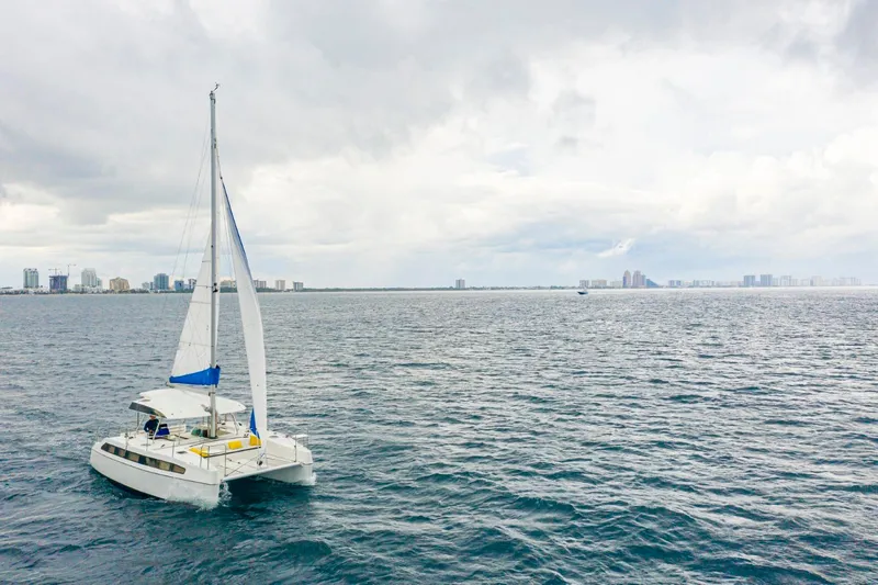  Yacht Photos Pics Sailing catamaran Smart Cat S280 on open sea with city skyline in background, 2025 model.