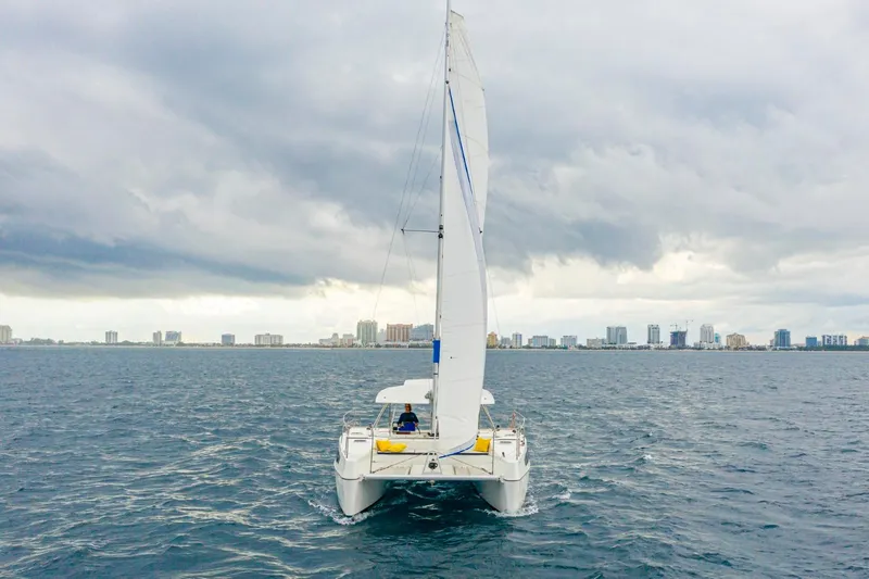  Yacht Photos Pics Sailing catamaran Smart Cat S280, 2025 model, on open water with city skyline.