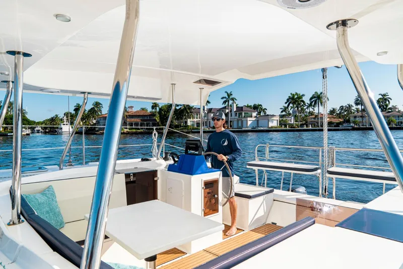  Yacht Photos Pics Man steering Smart Cat S280 boat on sunny waterfront, 2025 model.