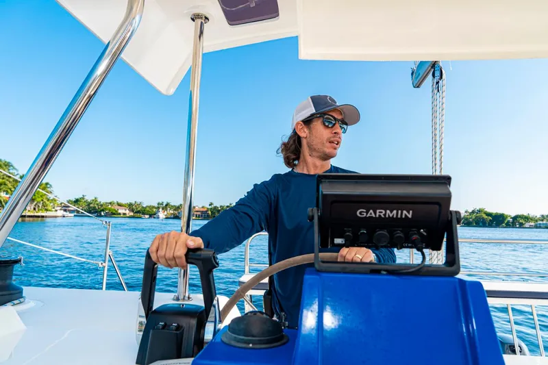  Yacht Photos Pics Man steering a Smart Cat S280 boat, 2025 model, on a sunny day.