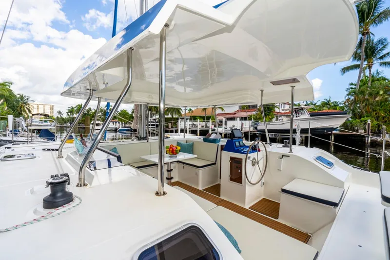 Yacht Photos Pics Modern Smart Cat S280 yacht interior with seating, steering wheel, and tropical marina backdrop.