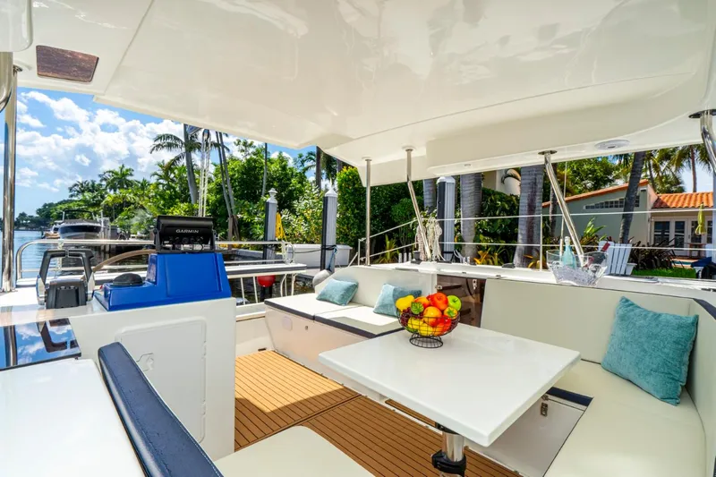  Yacht Photos Pics Luxurious Smart Cat S280 yacht interior with seating, table, and fruit bowl, surrounded by tropical scenery.