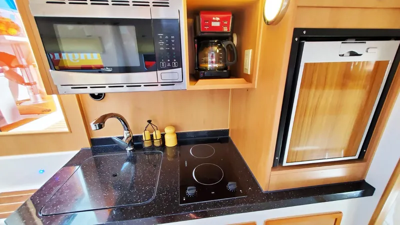  Yacht Photos Pics Compact kitchen in Smart Cat S280, 2025 model, featuring modern appliances and sleek design.