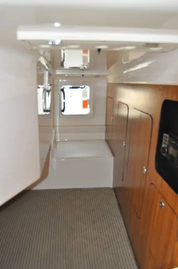  Yacht Photos Pics 2014 Pursuit OS 315 Offshore cabin interior with wood paneling and carpeted floor.