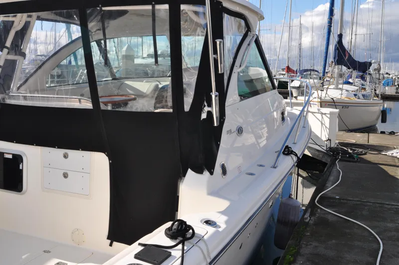  Yacht Photos Pics 2014 Pursuit OS 315 Offshore boat docked at marina, featuring sleek design and black canopy.