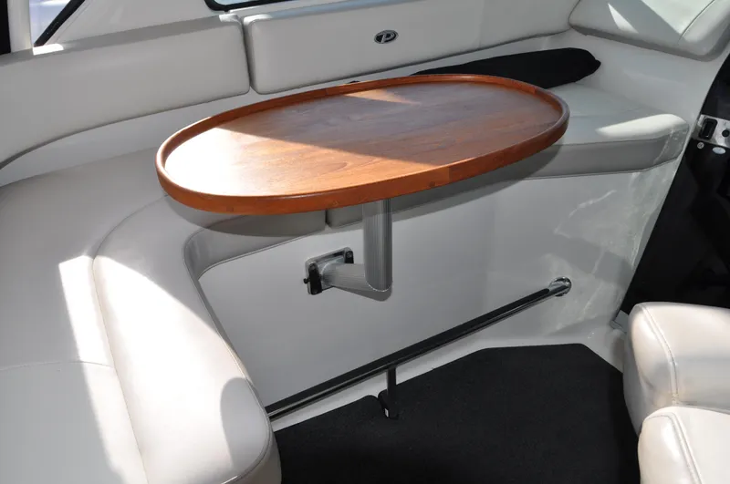  Yacht Photos Pics 2014 Pursuit OS 315 Offshore interior with wooden table and cushioned seating.
