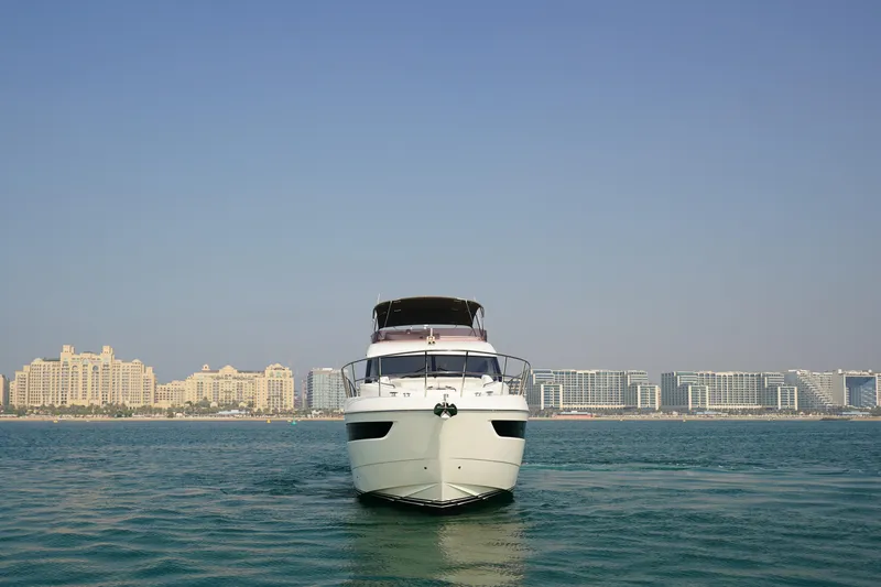 Princess F50 Model 2022 Yacht Photos Pics Front view of 2022 Princess F50 yacht on water with city skyline backdrop.