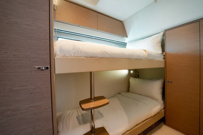 Princess F50 Model 2022 Yacht Photos Pics 2022 Princess F50 yacht interior with cozy bunk beds and wooden cabinetry.