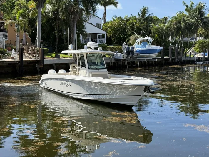  Yacht Photos Pics 2020 Boston Whaler 330 Outrage boat docked in a scenic waterfront setting.