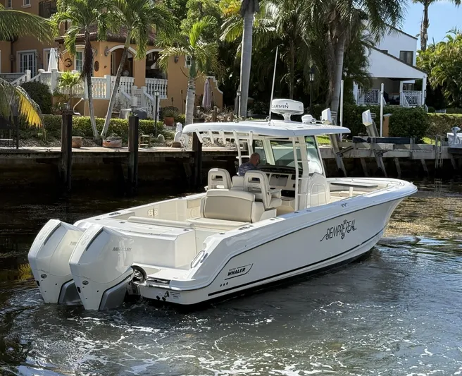  Yacht Photos Pics 2020 Boston Whaler 330 Outrage boat docked near tropical waterfront homes.
