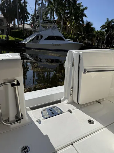  Yacht Photos Pics 2020 Boston Whaler 330 Outrage boat interior with docked yacht and palm trees in background.