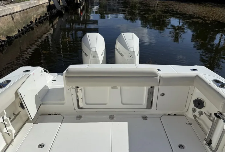  Yacht Photos Pics 2020 Boston Whaler 330 Outrage boat with twin Mercury engines, docked in calm water.
