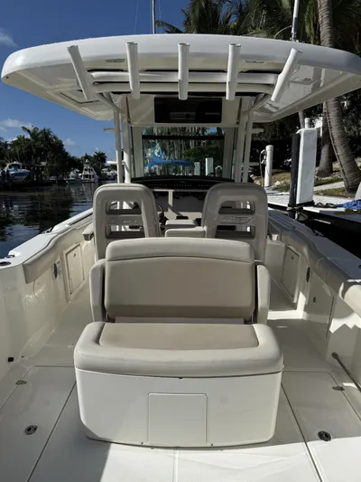  Yacht Photos Pics 2020 Boston Whaler 330 Outrage boat interior with seating and helm, docked near palm trees.