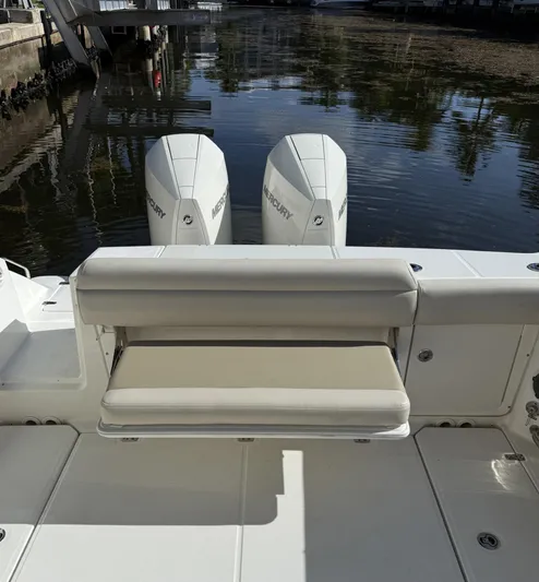  Yacht Photos Pics 2020 Boston Whaler 330 Outrage boat with dual Mercury engines, docked by the water.