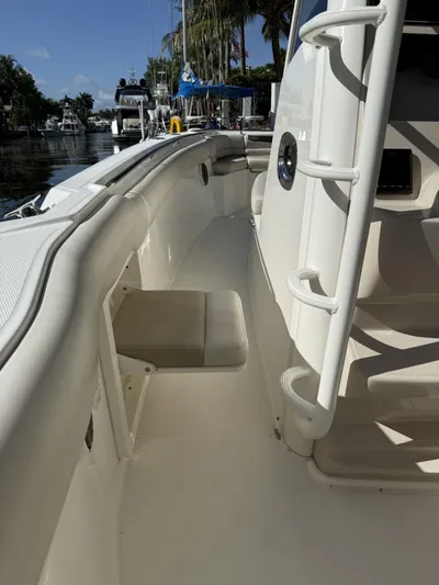  Yacht Photos Pics 2020 Boston Whaler 330 Outrage boat interior with seating and ladder, docked near palm trees.
