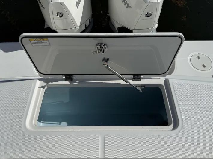  Yacht Photos Pics Open storage compartment on a 2020 Boston Whaler 330 Outrage boat, with Mercury engines visible.