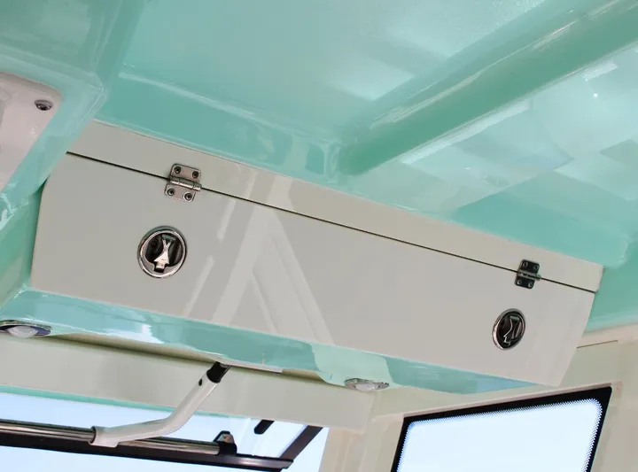  Yacht Photos Pics 2021 Robalo 272 boat interior storage compartment with teal accents.