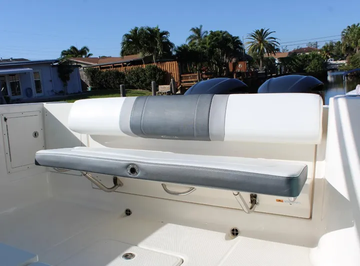  Yacht Photos Pics 2021 Robalo 272 boat with foldable seating, docked near palm trees.