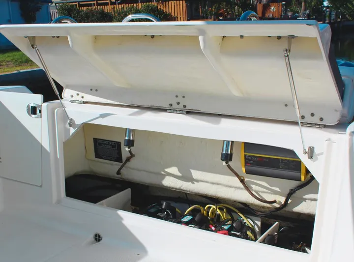 Yacht Photos Pics Open storage compartment of 2021 Robalo 272 boat, showcasing wiring and equipment.