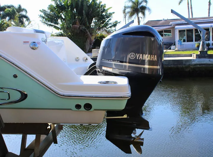  Yacht Photos Pics 2021 Robalo 272 boat with Yamaha outboard motor, docked by a canal.
