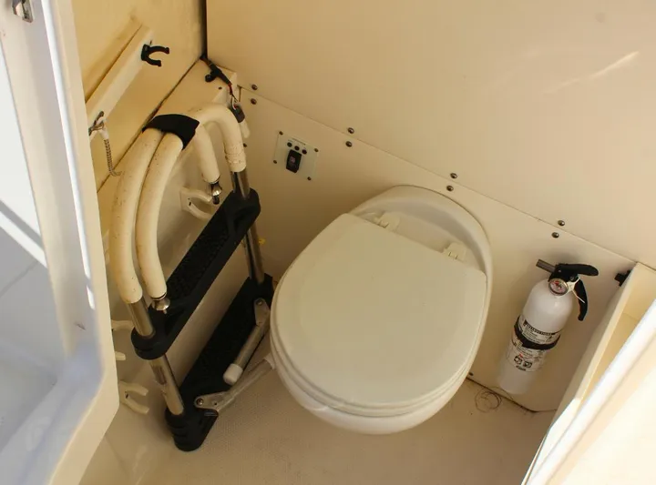  Yacht Photos Pics 2021 Robalo 272 boat interior with toilet and fire extinguisher.