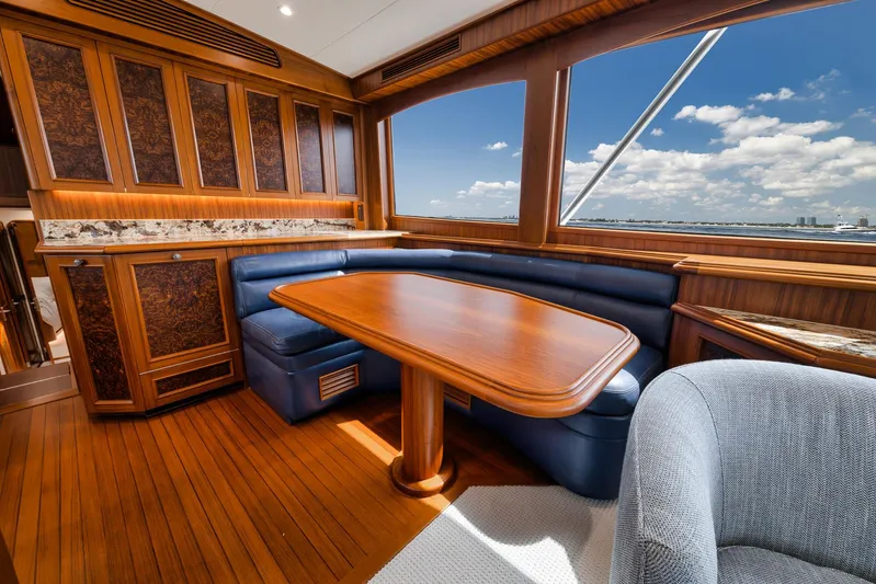  Yacht Photos Pics Luxurious interior of 2011 Jim Smith Custom Sportfish yacht with wooden table and blue seating.