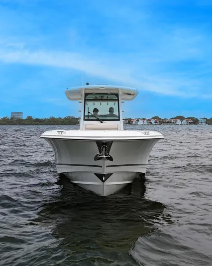  Yacht Photos Pics 2021 Boston Whaler 330 Outrage boat on water, clear blue sky background.