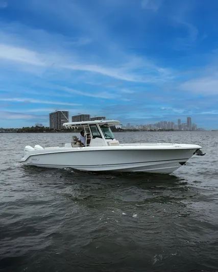  Yacht Photos Pics 2021 Boston Whaler 330 Outrage boat on water with city skyline background.