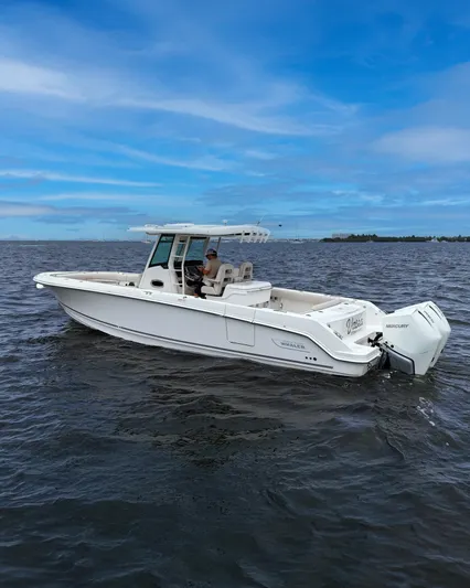  Yacht Photos Pics 2021 Boston Whaler 330 Outrage boat on open water under a clear blue sky.
