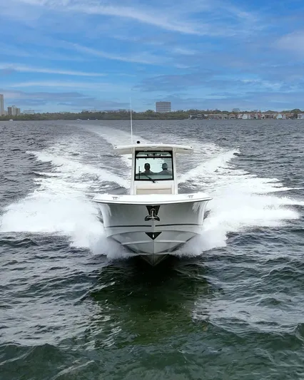  Yacht Photos Pics 2021 Boston Whaler 330 Outrage cruising on open water under a clear blue sky.