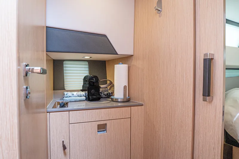  Yacht Photos Pics 2024 Fjord 41 XP interior kitchenette with modern appliances and wooden cabinetry.