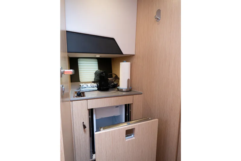  Yacht Photos Pics 2024 Fjord 41 XP yacht interior kitchenette with modern appliances and wooden cabinetry.