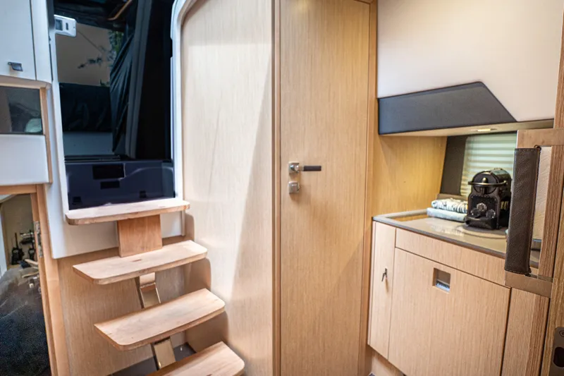  Yacht Photos Pics 2024 Fjord 41 XP interior with wooden stairs and modern cabinetry.