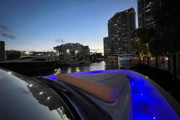  Yacht Photos Pics 2024 Fjord 41 XP yacht with blue LED lights docked at night in urban marina.
