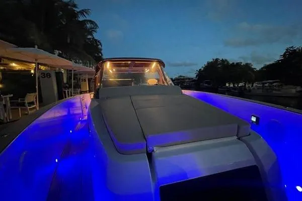  Yacht Photos Pics 2024 Fjord 41 XP yacht with blue LED lights at night, docked near palm trees.