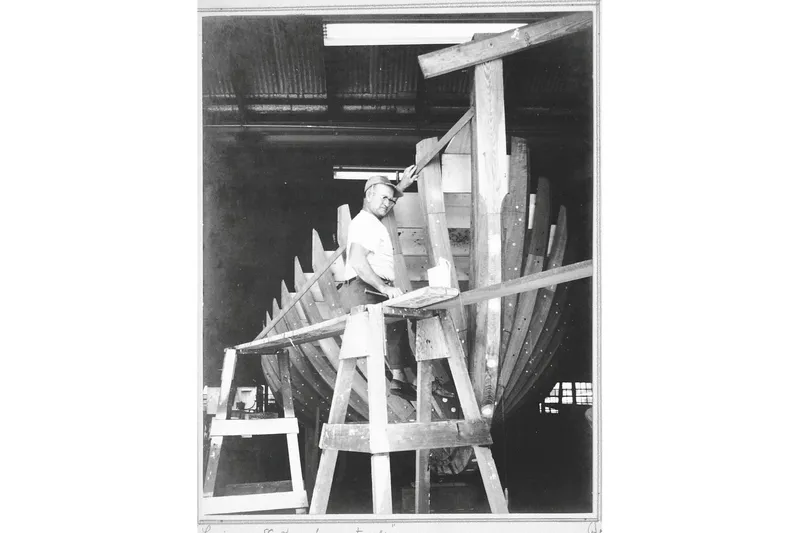 Clark Mills Yacht Photos Pics Man constructing 1972 custom tug boat in workshop, wooden framework visible.