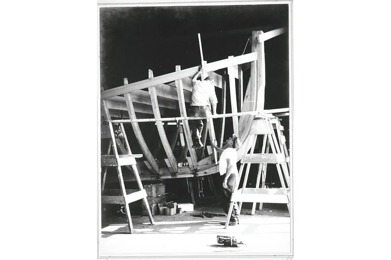 Clark Mills Yacht Photos Pics 1972 custom tug boat under construction, workers assembling wooden frame in shipyard.