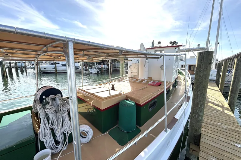 Clark Mills Yacht Photos Pics Custom 1972 tug boat docked at marina, featuring ropes and covered deck.