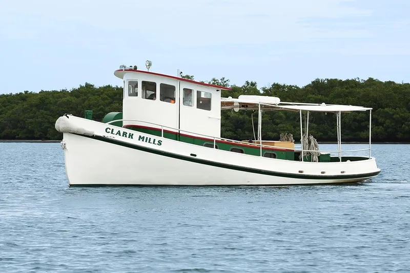 Clark Mills Yacht Photos Pics 1972 Mills Boat Works Tug Boat on calm water, lush greenery in background.