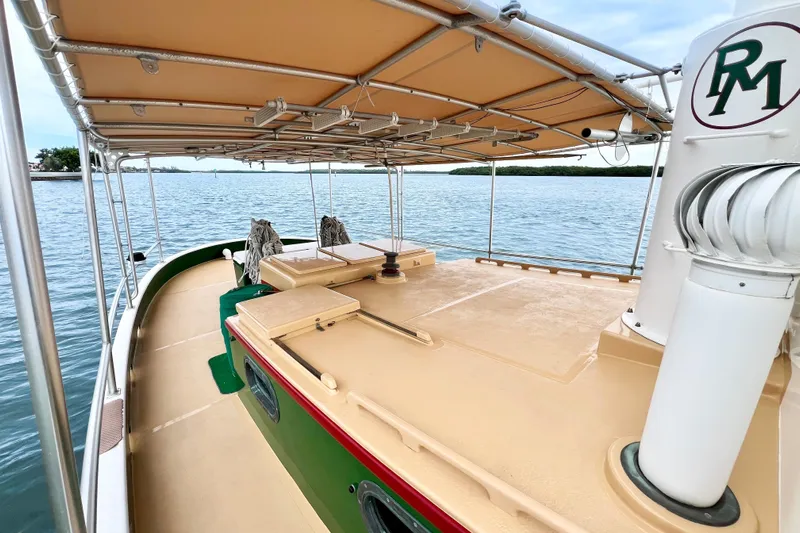 Clark Mills Yacht Photos Pics 1972 Mills Boat Works Tug Boat on calm water, featuring a covered deck and classic design.