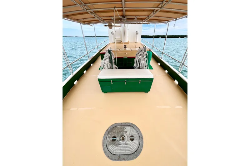 Clark Mills Yacht Photos Pics 1972 Mills Boat Works Tug Boat deck with ropes and seating, on calm water.