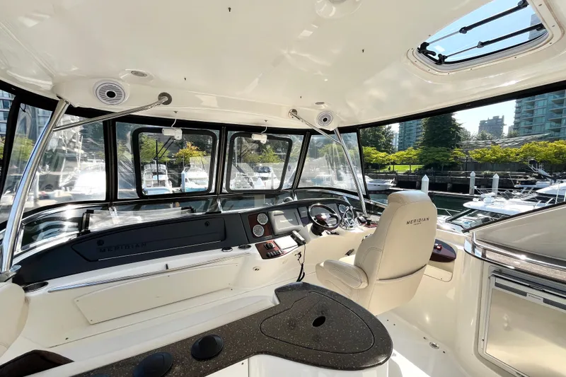  Yacht Photos Pics Interior view of 2012 Meridian 441 Sedan yacht cockpit with modern controls and marina backdrop.
