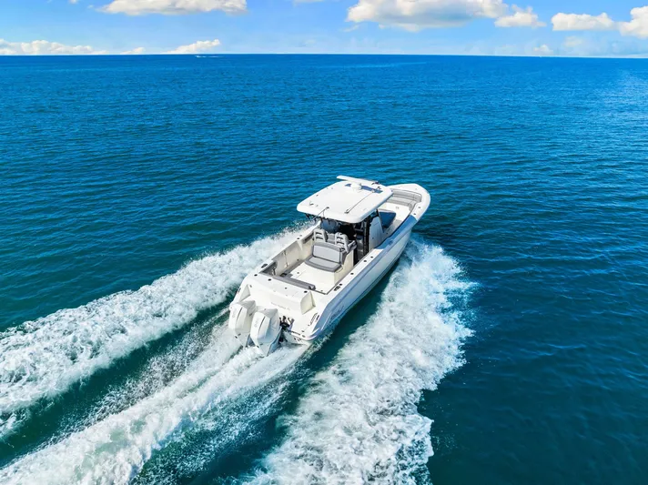  Yacht Photos Pics 2022 Boston Whaler 330 Outrage cruising on open blue ocean waters.