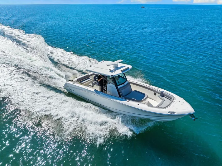  Yacht Photos Pics 2022 Boston Whaler 330 Outrage cruising on clear blue ocean waters.