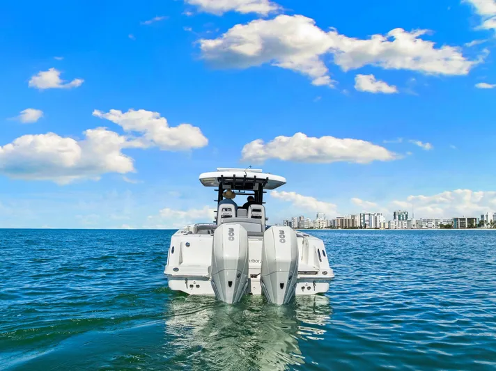 Yacht Photos Pics 2022 Boston Whaler 330 Outrage on open water with city skyline in background.