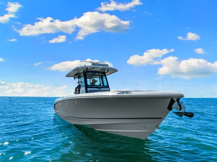  Yacht Photos Pics 2022 Boston Whaler 330 Outrage boat on clear blue ocean under a bright sky.