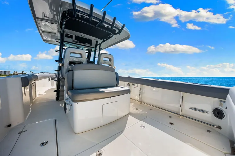  Yacht Photos Pics 2022 Boston Whaler 330 Outrage boat interior with seating, under a clear blue sky.