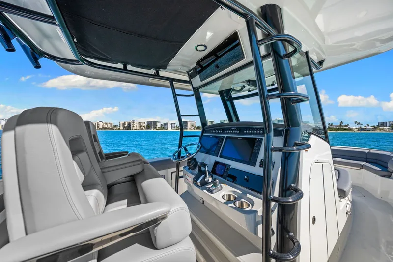  Yacht Photos Pics Interior view of 2022 Boston Whaler 330 Outrage boat with modern dashboard and seating.