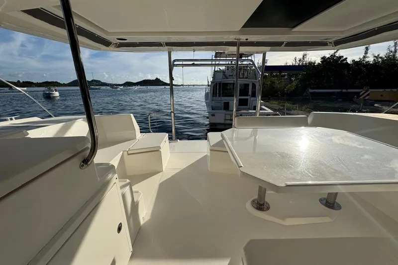 Stargazer Yacht Photos Pics 2017 Robertson and Caine Leopard yacht deck with seating and table, overlooking serene waters.